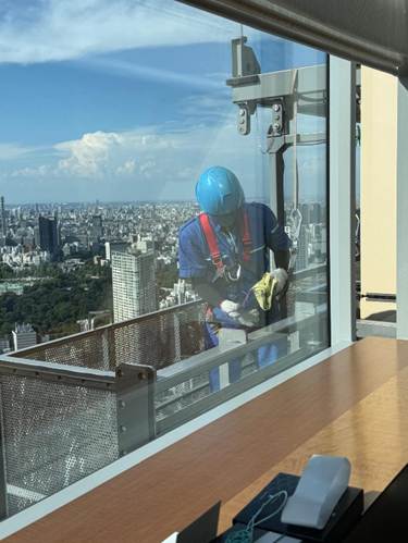 A person in a blue helmet cleaning a window

AI-generated content may be incorrect.