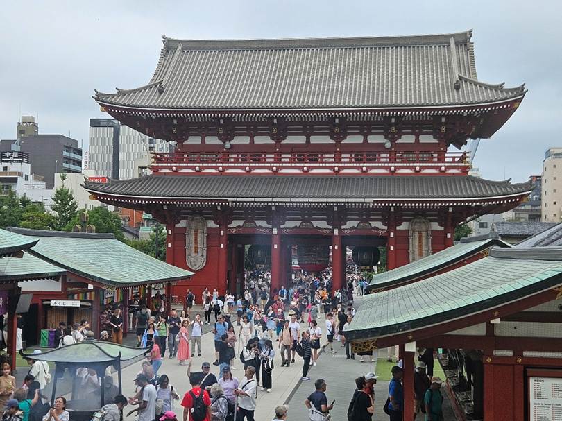 A group of people walking in a street with Sensō-ji in the background

AI-generated content may be incorrect.