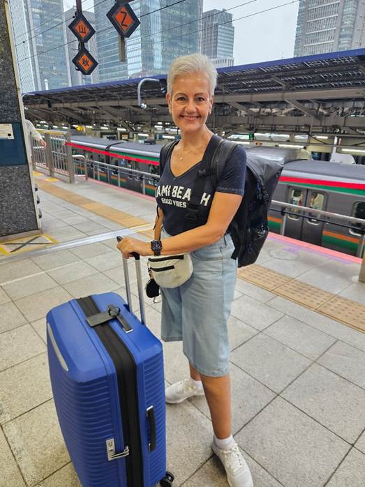 A person standing with luggage at a train station

AI-generated content may be incorrect.