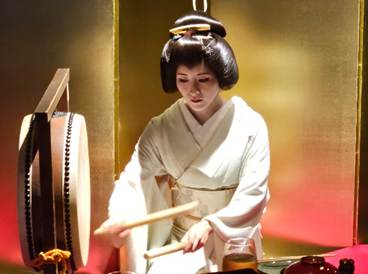 A person in a white robe playing drums

AI-generated content may be incorrect.