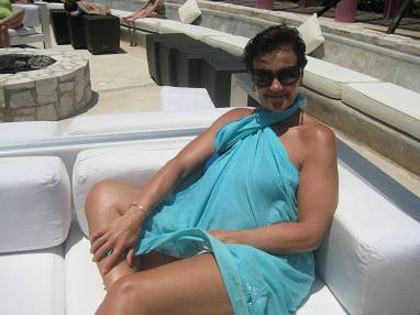 Caroline relaxing on a white sofa by the pool