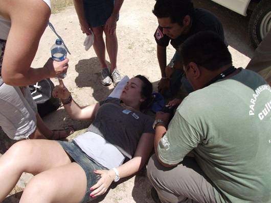 Sian being tended to by paramedics after fainting at Chichen Itza
