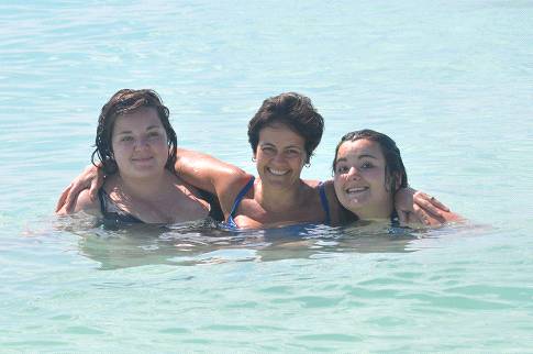 Three of the family swimming together in the clear blue sea