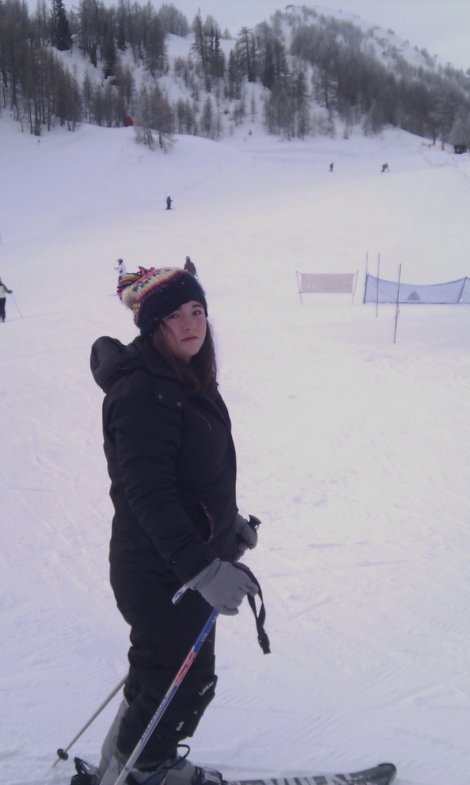 On the slope with skis and poles, ski lift in the background