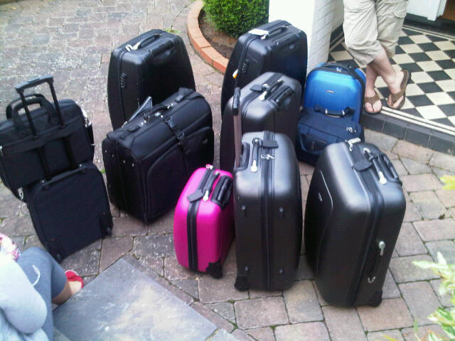 A pile of suitcases on the driveway before departure