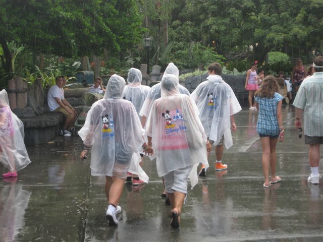 Family in Disney ponchos walking through the rain