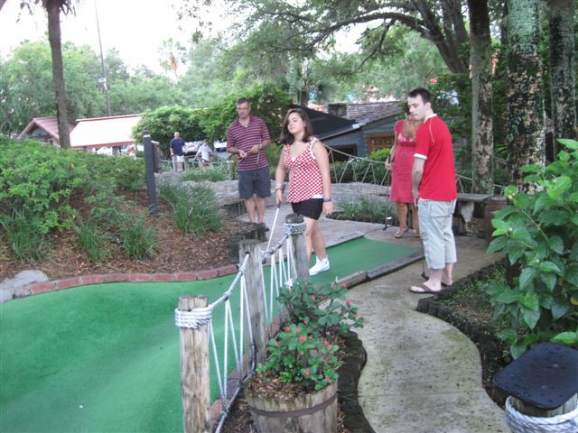 The family playing mini golf