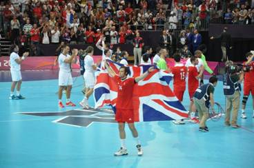 The GB handball team saluting the crowd with a Union flag after the match