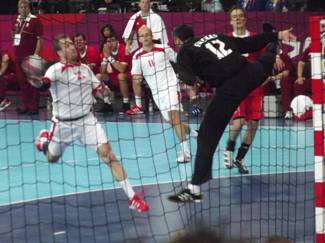 A handball player challenging for the ball mid-match