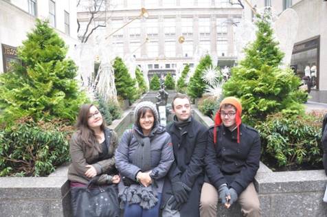 The family sitting among the Christmas trees at Rockefeller Center